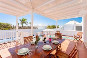 a dining room with a table and chairs on a deck at Villa Tania in Puerto del Carmen