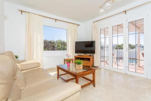 a living room with a white couch and a television at Villa Tania in Puerto del Carmen