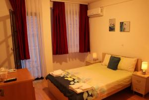 a hotel room with a bed with red curtains at Apartmani Marija in Ohrid