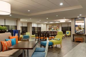 a waiting room with colorful chairs and tables at Home2 Suites By Hilton Gainesville in Gainesville