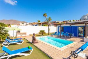 a villa with a swimming pool and a house at Villa Tropical in Playa Blanca