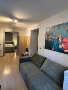 ein Wohnzimmer mit einem Sofa und einem Gemälde an der Wand in der Unterkunft Carpe Diem Corinthian Suites 2 in Krínai