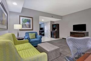 a living room with furniture and a flat screen tv at Hilton Garden Inn and Fayetteville Convention Center in Fayetteville
