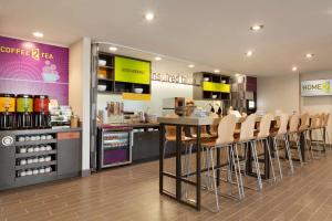 a restaurant with a bar with chairs and a counter at Home2 Suites by Hilton Gillette in Gillette