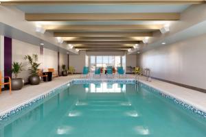 a pool in a hotel lobby with blue chairs at Home2 Suites by Hilton Gillette in Gillette