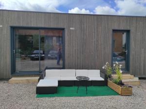 a white couch sitting in front of a building at Studio cosy in Niederroedern