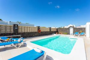 a swimming pool with two lounge chairs and a swimming pool at Villa Zoe in Los Pocillos