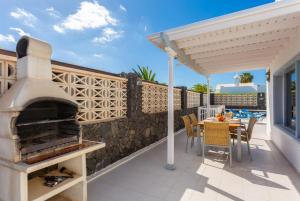 patio con horno al aire libre, mesa y sillas en Villa Zoe, en Los Pocillos 38 fotos más
