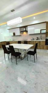 une salle à manger avec une table et des chaises blanches dans l'établissement Luxurious apartment with heated pool jacuzzi, 
