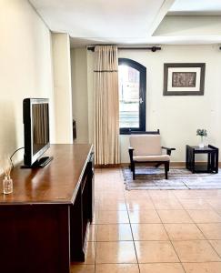 sala de estar con TV y sofá en Hotel Renacer Tarija, en Tarija