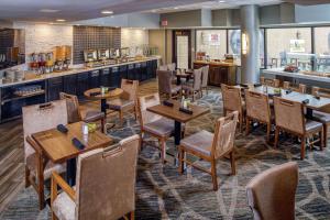 a restaurant with wooden tables and chairs and a counter at DoubleTree by Hilton Appleton, WI in Appleton