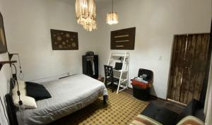 ein Schlafzimmer mit einem Bett und einem Stuhl darin in der Unterkunft En Remolinos in Cruz del Eje