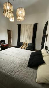ein Schlafzimmer mit einem großen Bett mit zwei Kronleuchtern in der Unterkunft En Remolinos in Cruz del Eje