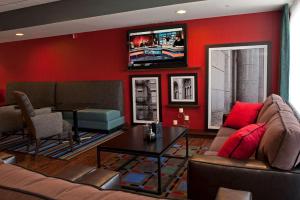 a living room with a couch and a tv on a wall at Hampton Inn Grand Rapids-South in Wyoming