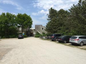 un estacionamiento con autos estacionados frente a una casa en Appartement Anker, en Hollum