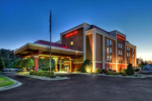 un bâtiment d'hôtel avec drapeau dans un parking dans l'établissement Hampton Inn Goldsboro, à Goldsboro