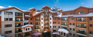 een uitzicht op een gebouw met een berg op de achtergrond bij The Lodge at Mountaineer Square in Mount Crested Butte