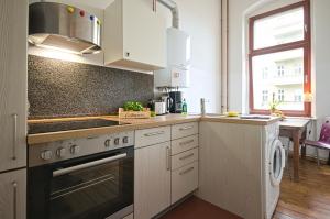 2 Bedroom Apartment (ABEMI) في برلين: مطبخ بخزائن بيضاء وفرن موقد