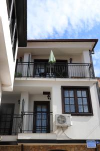 a white building with a balcony with a fan at Apartmani Marija in Ohrid