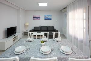 un comedor con una mesa con platos blancos. en Apartamento Turístico VIANA I, en Viana
