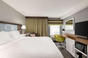 een hotelkamer met een groot bed en een bureau bij Hampton Inn Greenville-Simpsonville in Simpsonville