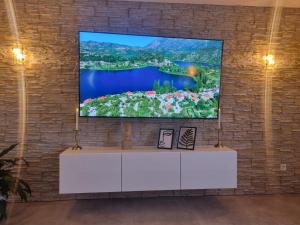 a flat screen tv hanging on a brick wall at Wellness Ferienhaus in Mechernich
