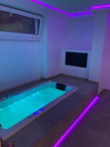 a room with a swimming pool with purple lights at Wellness Ferienhaus in Mechernich