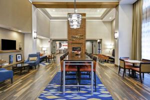 a lobby with tables and chairs and a fireplace at Hampton Inn & Suites Grants Pass in Grants Pass