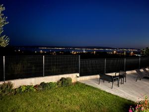 a patio with two chairs and a table at night at BAVA in Kaštela