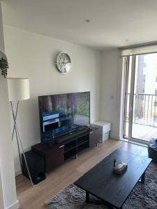 a living room with a large flat screen tv at Luxury one bedroom apartment in London