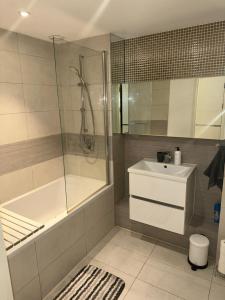 a bathroom with a shower and a tub and a sink at Luxury one bedroom apartment in London