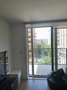 a living room with a large sliding glass door with a balcony at Luxury one bedroom apartment in London