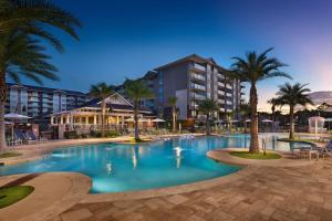 un complejo con piscina con palmeras y un edificio en Hilton Grand Vacations Club Ocean Oak Resort Hilton Head, en Hilton Head Island