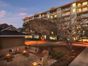 a building with a courtyard with furniture and a tree at Hilton Grand Vacations Club Ocean Oak Resort Hilton Head in Hilton Head Island