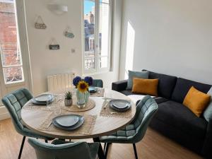 a living room with a table and a couch at La Capitainerie in Le Tréport