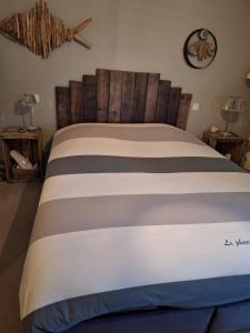 - une chambre avec un lit et une tête de lit en bois dans l'établissement Woodland's House, à Hermanville-sur-Mer