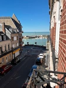 a view of a city street with cars parked on the street at La Capitainerie in Le Tréport