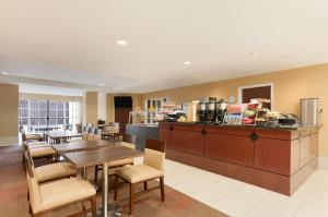 a restaurant with a table and chairs and a kitchen at Hawthorn Suites by Wyndham College Station in College Station