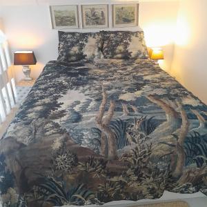 Un dormitorio con una cama con una manta con árboles. en Cosy Cottage, 