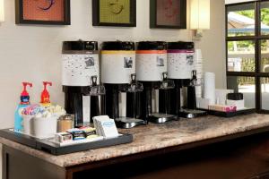 um balcão com uma fila de máquinas de café sobre ele em Hampton Inn Hilton Head em Hilton Head Island