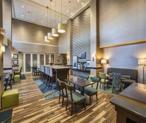 a restaurant with tables and chairs and a bar at Hampton Inn Hibbing in Hibbing