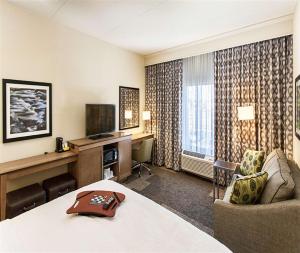 Habitación de hotel con cama y sala de estar. en Hampton Inn Hibbing, en Hibbing