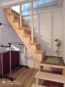 eine Treppe in einem winzigen Haus mit einem Bett in der Unterkunft RYTO GARSAI in Merkinė