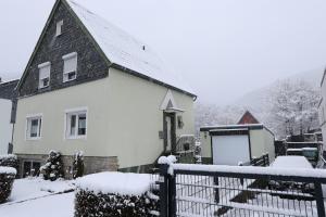 a white house with a black roof covered in snow at Ferienhaus Alte Maßschneiderei in Schleiden +36 photos