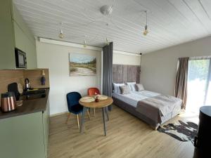 Schlafzimmer mit einem Bett, einem Tisch und Stühlen in der Unterkunft Grey apartments in Slawske