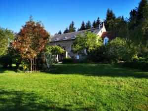an old stone house in a field of grass at DOMAINE DES CAPUCINS in Bussière-Saint-Georges
