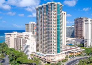 Hilton Grand Vacation Club The Grand Islander Waikiki Honolulu في هونولولو: اطلالة جوية على مبنى طويل في مدينة