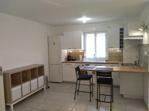 cocina con mesa, sillas y nevera en Appartement T2, 4 personnes, disponible jusqu au Samedi 2 sept 2023 en Le Cannet-des-Maures