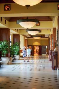 two people walking through the lobby of a hotel at Hilton Grand Vacations Club Grand Waikikian Honolulu in Honolulu
