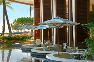 a row of tables and chairs with umbrellas at Hilton Grand Vacations Club Grand Waikikian Honolulu in Honolulu